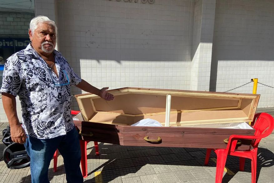 Homem coloca caixão na porta do INSS em protesto por perda de benefício: 'alegam que estou falecido'