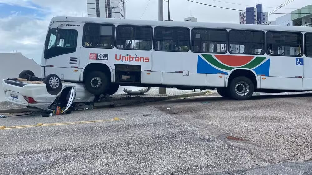 Carro de passeio fica embaixo de ônibus do transporte público de João Pessoa em acidente e três pessoas, entre elas uma criança, ficam feridas