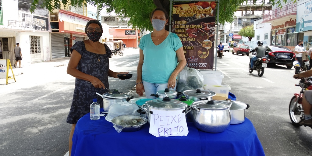 Dificuldades na pandemia levam mãe e filha a se unirem para oferecer comida regional em canteiro central, em Patos